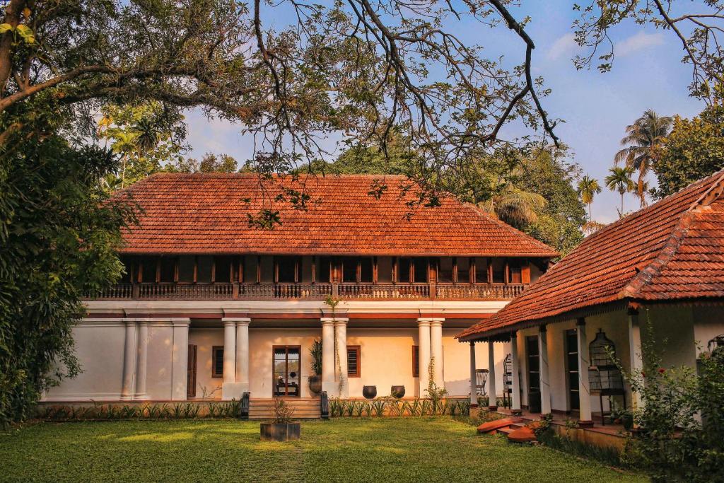 科欽的住宿－Chittoor Kottaram Royal Mansion- CGH Earth，一座在院子里有红色屋顶的老房子