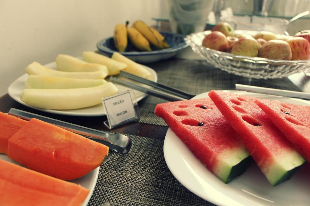 a table with plates of watermelon and other fruits at Hotel Recanto dos Ipes in Frutal