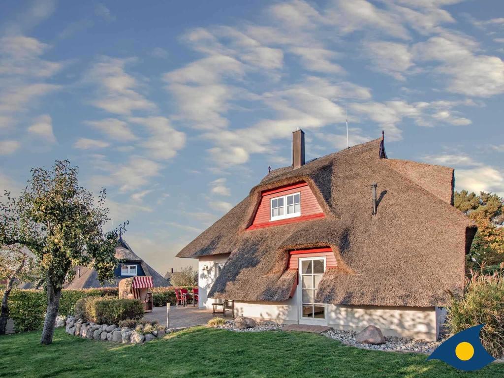 a thatch roofed house with a red roof at Haus Seemannsgarn in Heringsdorf