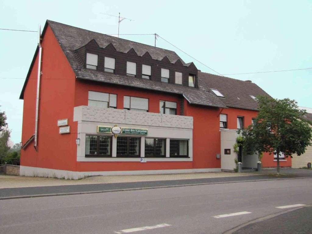 a red building on the side of a street at "Unter den Kastanien" in Speicher