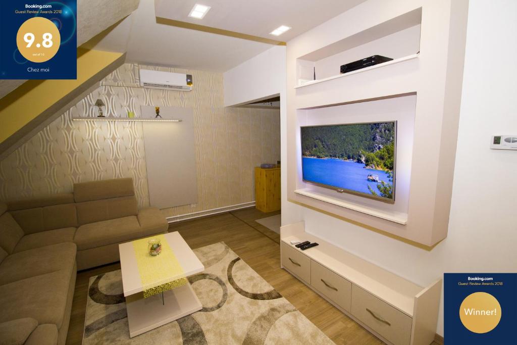 a living room with a tv on a wall at Chez moi in Debrecen
