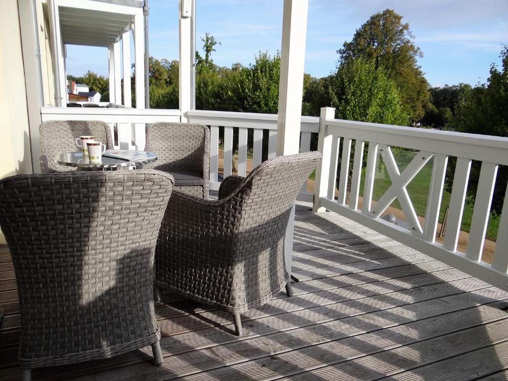 een patio met 2 stoelen en een tafel op een veranda bij Villa Parkblick, Whg. 17 in Kühlungsborn