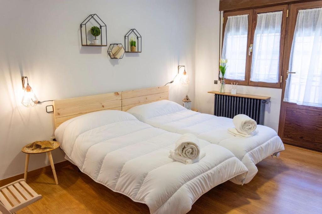 2 camas en una habitación con sábanas blancas en Toledo Mágico, en Madridejos