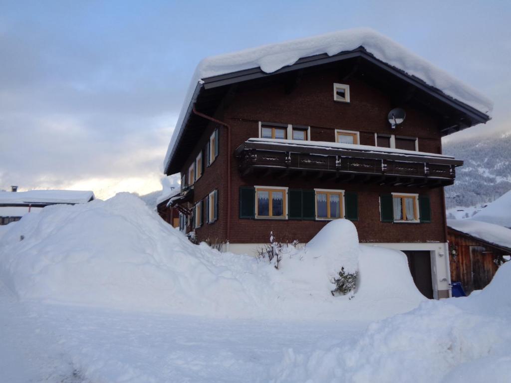 una gran pila de nieve frente a una casa en Haus Annelies en Au im Bregenzerwald