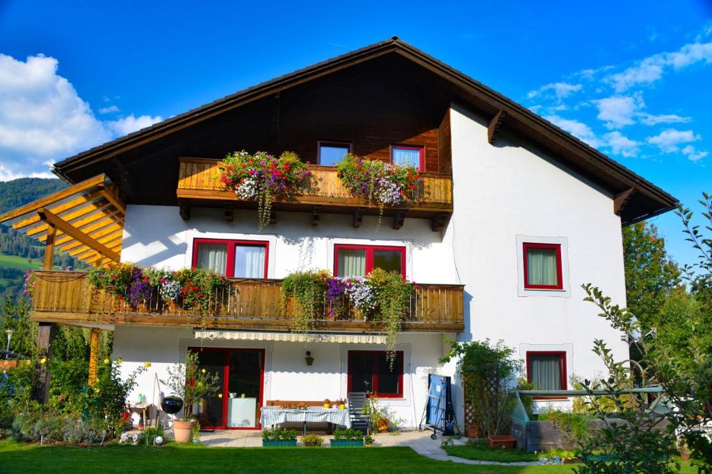 ein weißes Haus mit Blumen auf den Balkonen in der Unterkunft Haus Miriam in Sankt Lorenzen ob Murau