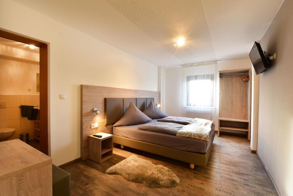 Schlafzimmer mit einem Bett und einem Fenster in der Unterkunft 1a Gästehaus am Hafen in Nürnberg