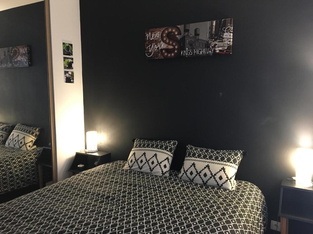 アニエール・シュル・セーヌにあるb&b du Clos Ménilのベッドルーム1室(ベッド2台、枕、ランプ2つ付)