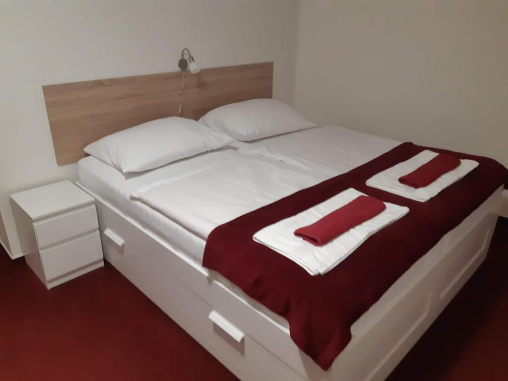 a large white bed with red and white blankets and pillows at Penzion Quattro in Ústí nad Orlicí