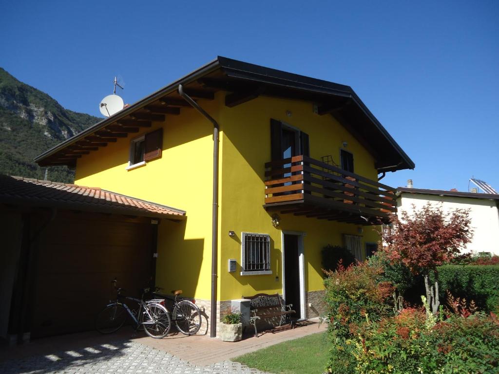een geel huis met buiten geparkeerde fietsen bij Casa Alice in Crone