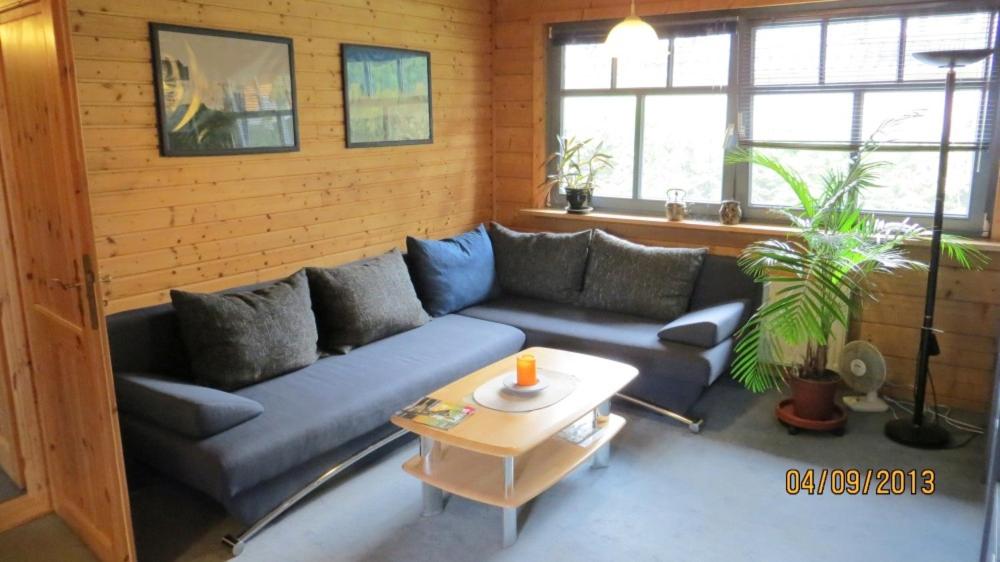 uma sala de estar com um sofá azul e uma mesa em Ferienwohnung Heucke em Berlim