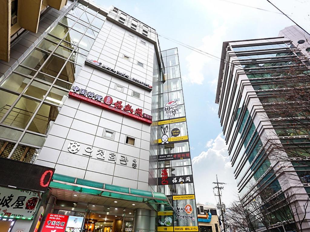 un edificio alto con señales en una ciudad en 24 Guesthouse Seoul City Hall, en Seúl