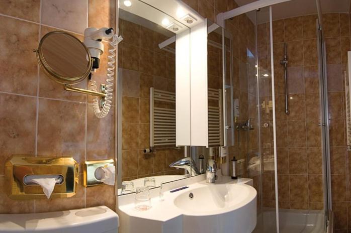 a bathroom with a sink and a shower with a mirror at Hotel Alter Speicher in Lübeck