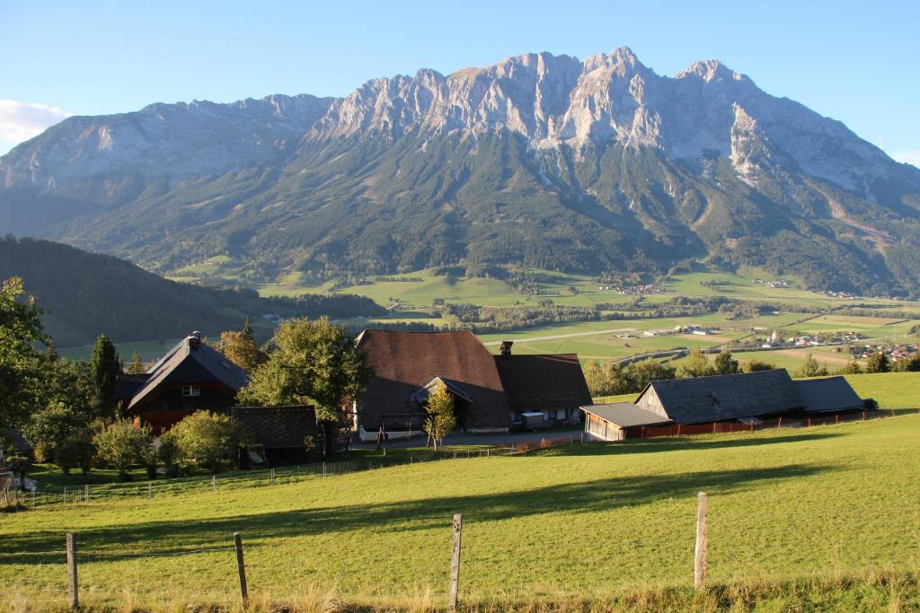 ein Bauernhof mit einem Berg im Hintergrund in der Unterkunft Ferienwohnung Krennbauer in Öblarn