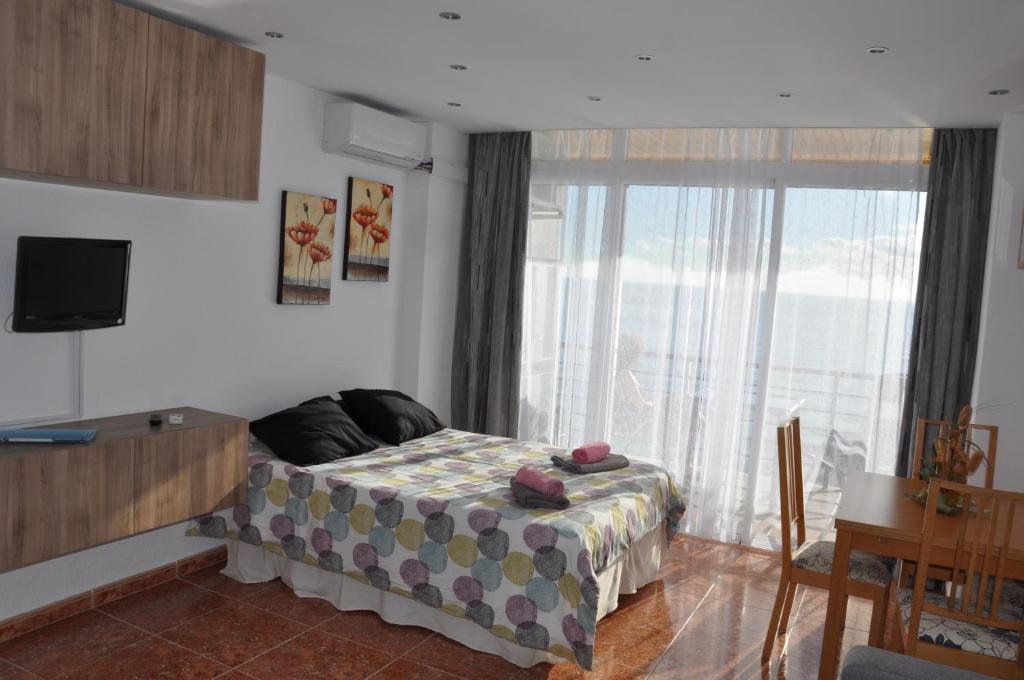 a bedroom with a bed and a tv and a window at Studio Vue Mer in Torremolinos