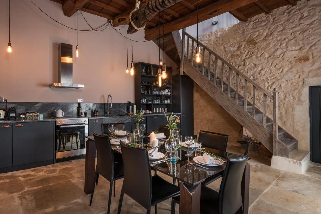 a dining room with a table and chairs and a staircase at Boutique Villa Kalliope in Gavalochori