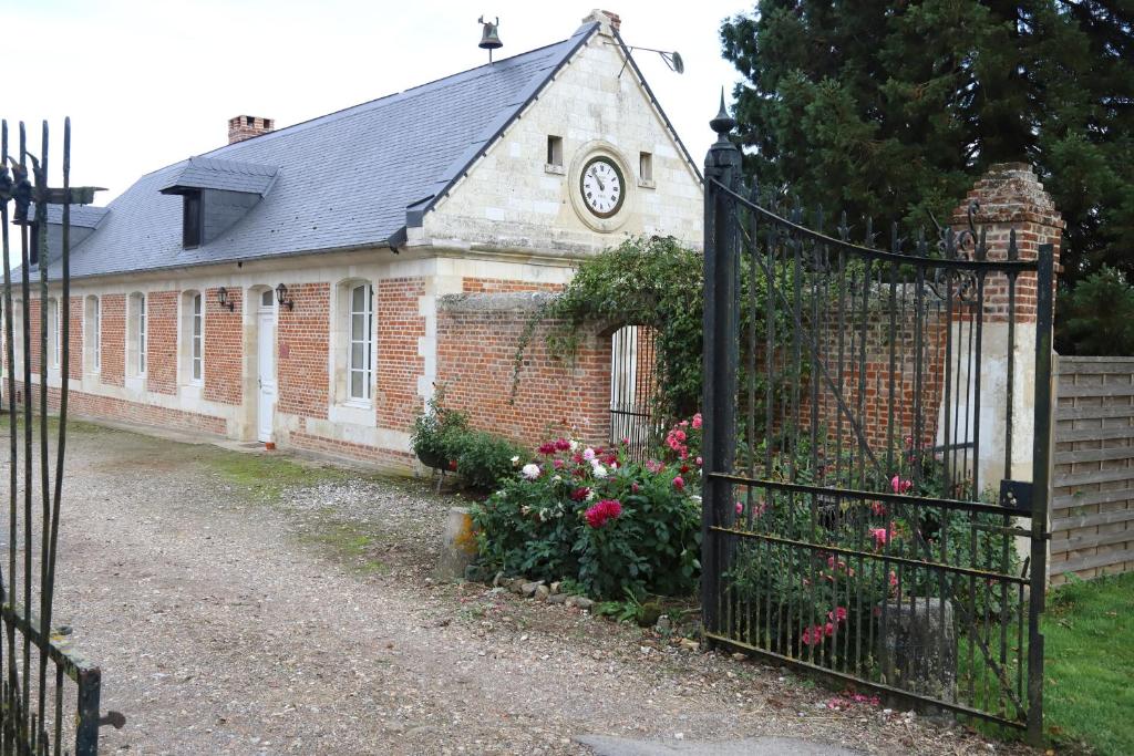 un edificio di mattoni con un orologio sopra di Maison de l'horloge a Courcelles-sous-Moyencourt