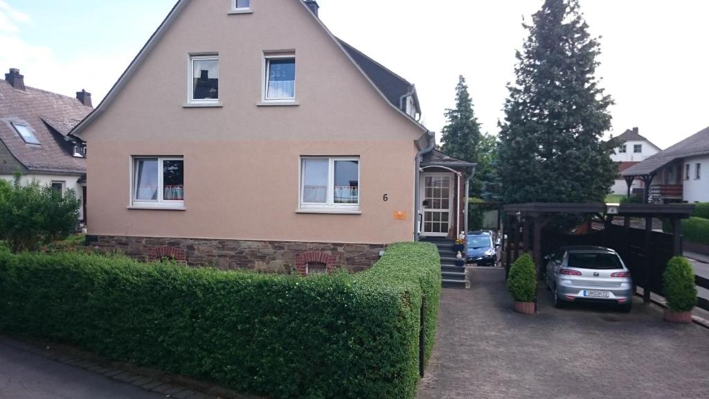 ein Haus mit einem Auto, das in einer Einfahrt geparkt ist in der Unterkunft Zum alten Schusterhaus in Bad Endbach