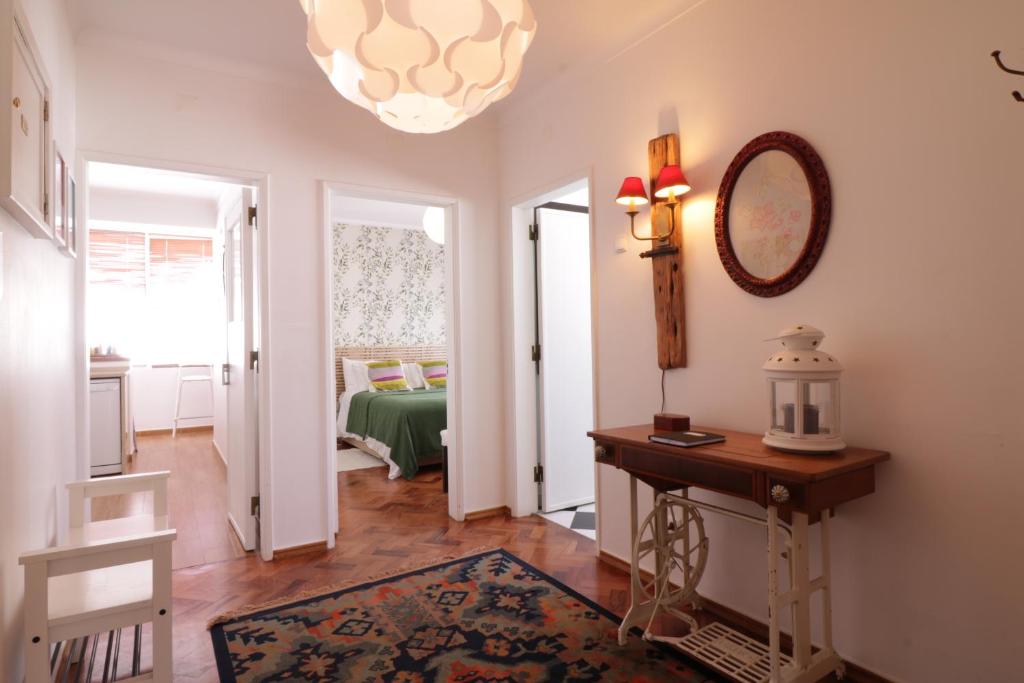 a hallway with a table and a mirror and a room at Apartamento de charme in Cascais