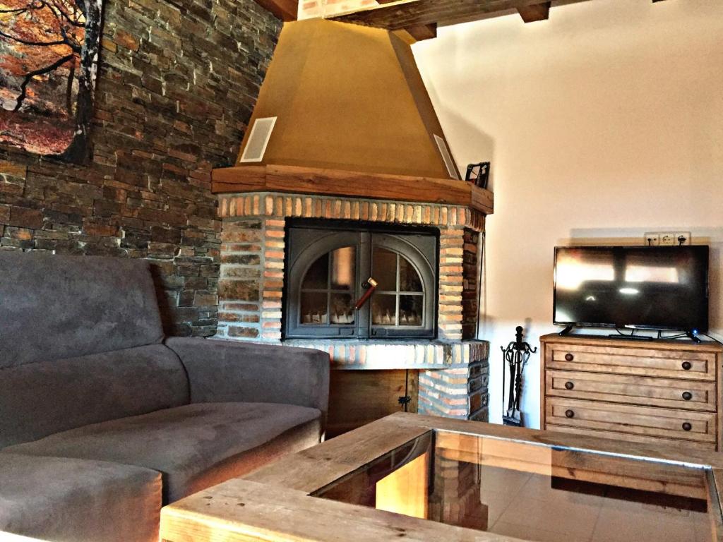 a living room with a couch and a fireplace at El Corral De Concejo in Horcajuelo de la Sierra