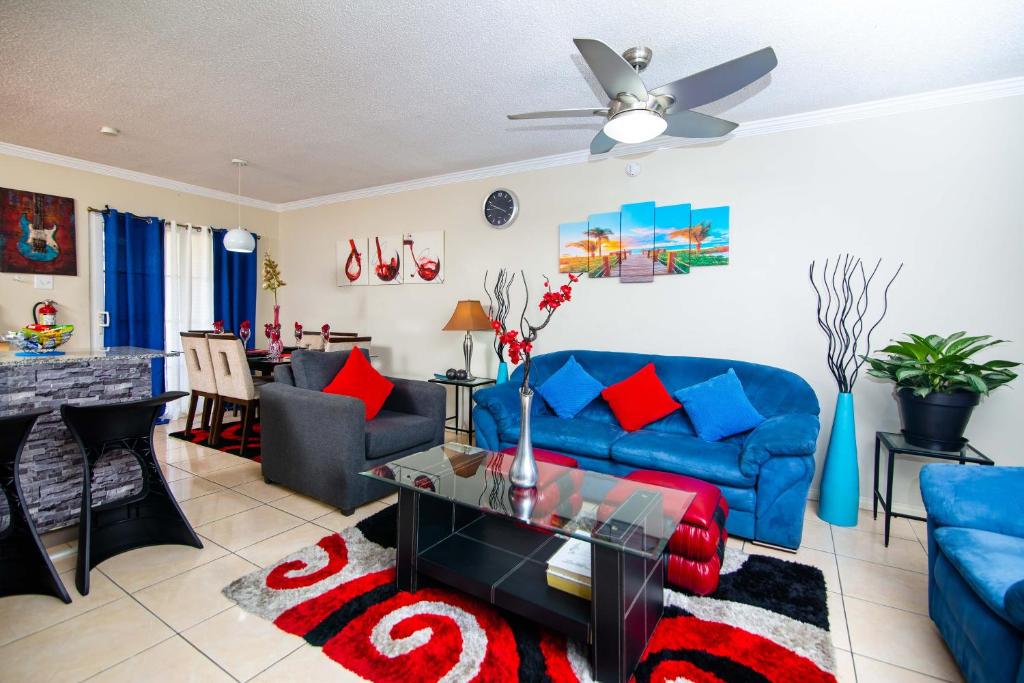 a living room with a blue couch and a table at The Oasis I, Portmore Country Club in Portmore