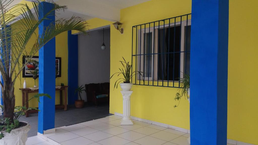 una habitación con una pared amarilla con plantas. en Pousada Salvatore, en Arraial do Cabo