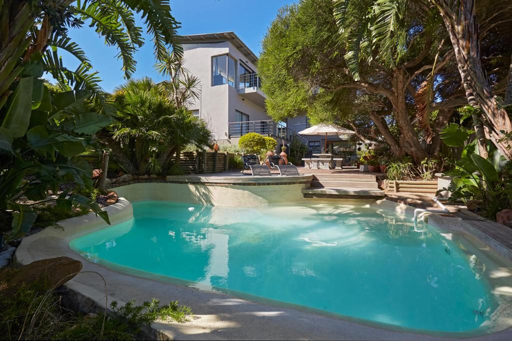 una piscina di fronte a una casa alberata di Villa Rhulani - Luxurious modern Villa in Hout Bay a Hout Bay