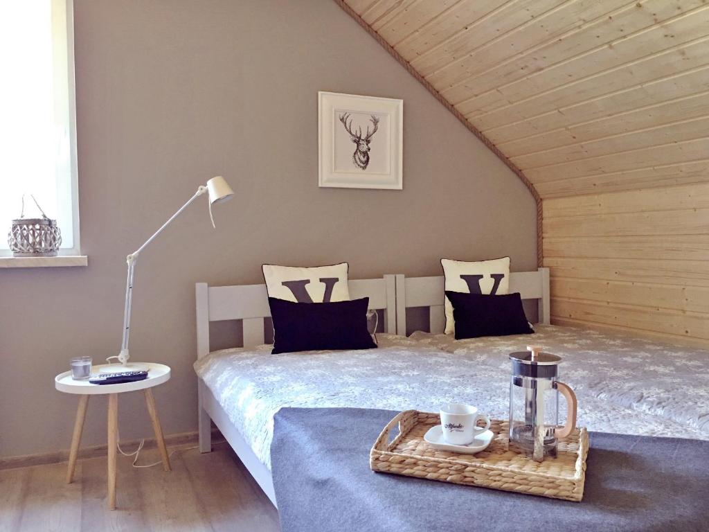 a bedroom with a bed and a table with a tray at Ośrodek VolfCamp Kwaszenina in Arłamów