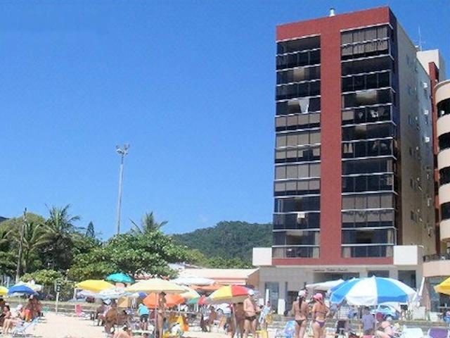 un grupo de personas en una playa con sombrillas y un edificio en Ultimo Andar, Frente ao Mar Itapema SC, en Itapema