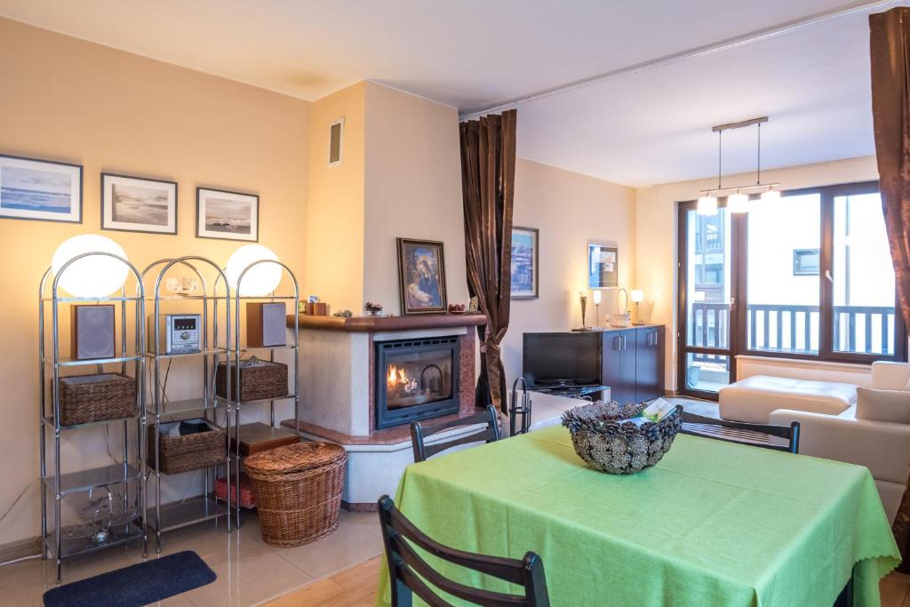 a living room with a table and a fireplace at Mountain Escape Bansko 1BR apartment in Bansko