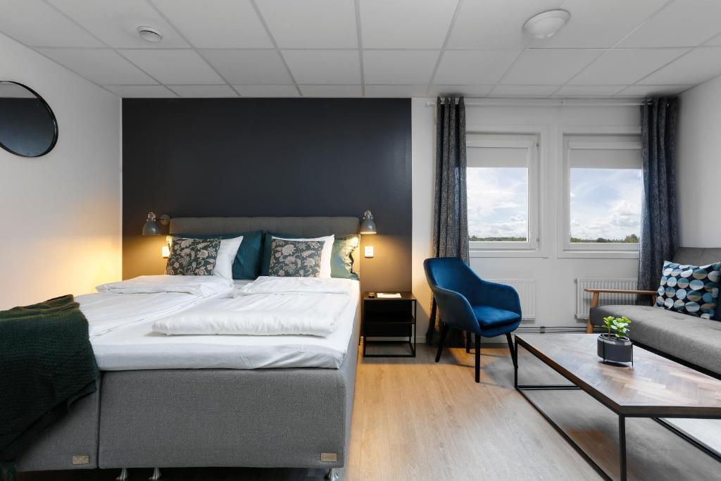 une chambre d'hôtel avec un lit et un canapé dans l'établissement Hotel Vindeus, à Södertälje