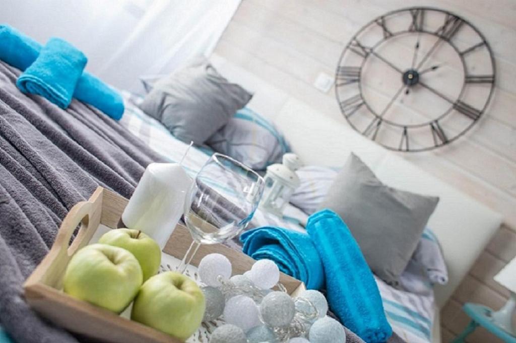 a table with a tray of apples and a clock at Apartamenty Perła Bałtyku in Władysławowo