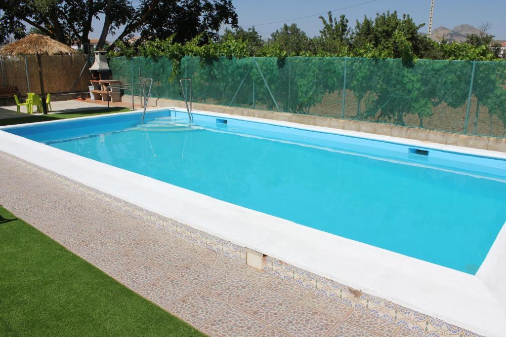a swimming pool in a backyard with a fence at Huerta Espinar - Casa rural con piscina privada in Archidona
