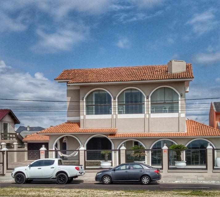 two cars parked in front of a building at Casa Beira-mar Atlântida Sul in Xangri-lá