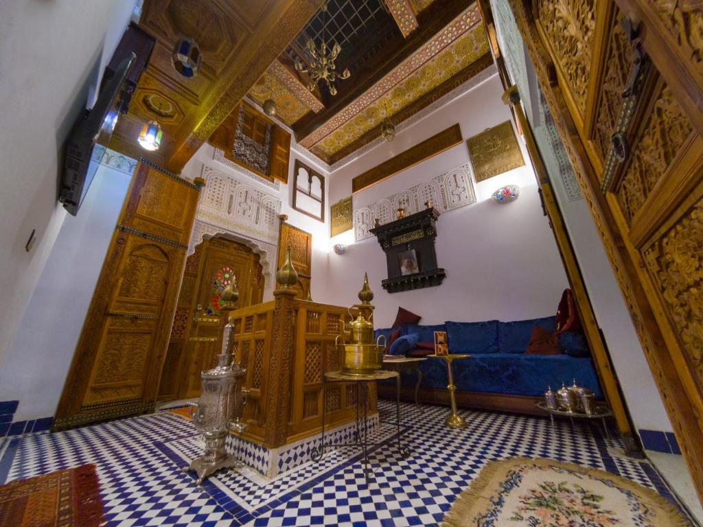 sala de estar con sofá azul y mesa en Dar Mfaddel, en Fez