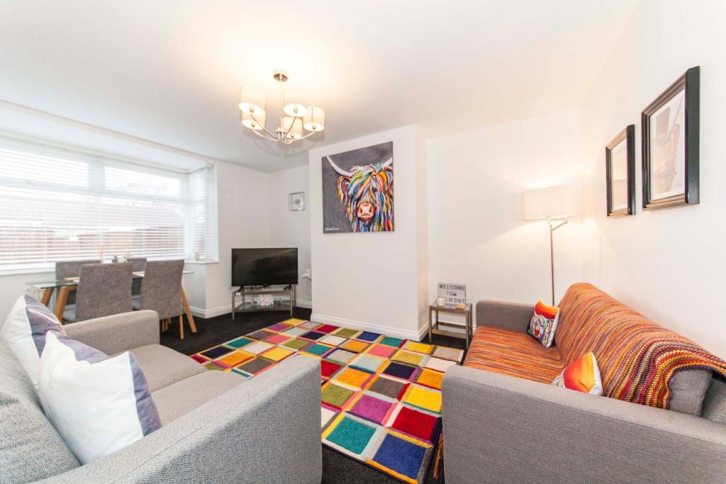 a living room with a couch and a television at Belmont Apartments in Billingham