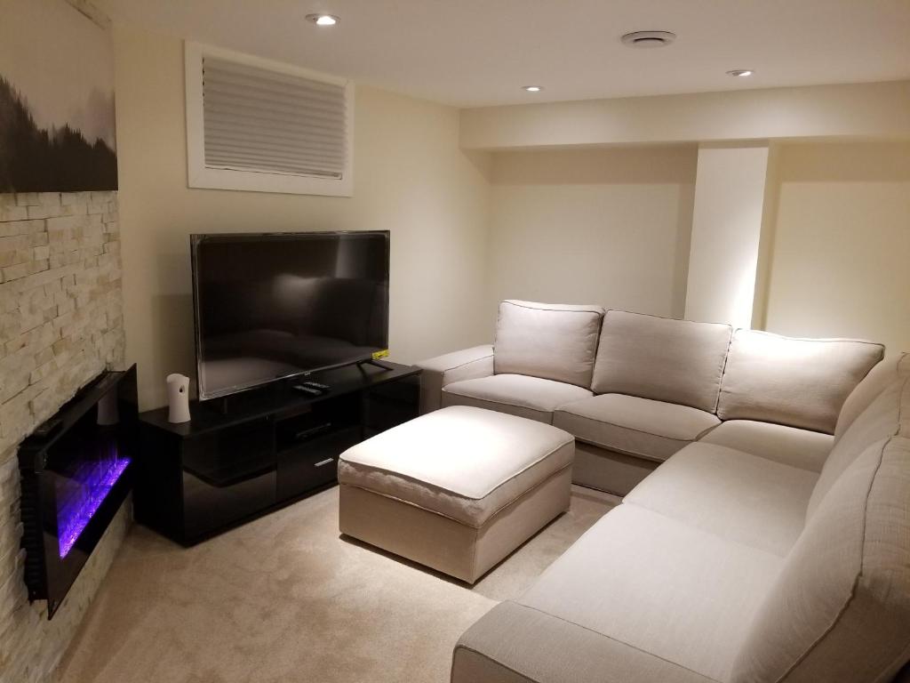 ein Wohnzimmer mit einem Sofa und einem Flachbild-TV in der Unterkunft Your perfect stay away from home in Winnipeg