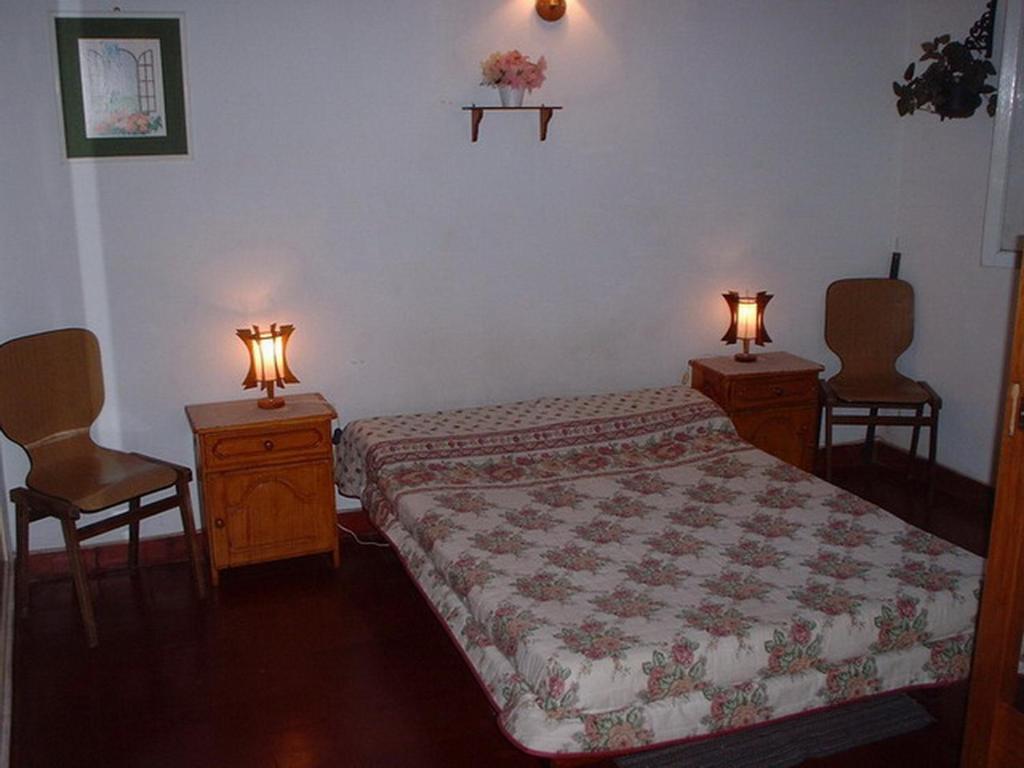 1 dormitorio con 1 cama, 2 mesas y 2 luces en Avenida 2, 3344 en Villa Gesell