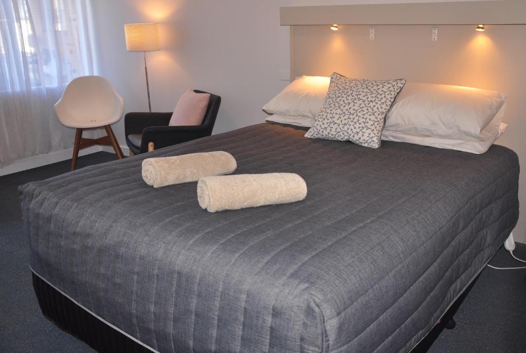 1 dormitorio con 1 cama grande y 2 toallas. en Maffra Motor Inn, en Maffra