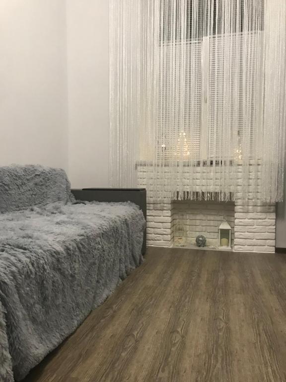 een witte slaapkamer met een bed en een open haard bij Cozy and comfortable apartment in Lviv