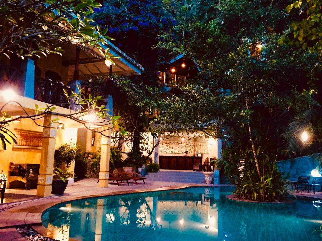 a swimming pool in front of a house at night at Thambapanni Retreat in Unawatuna