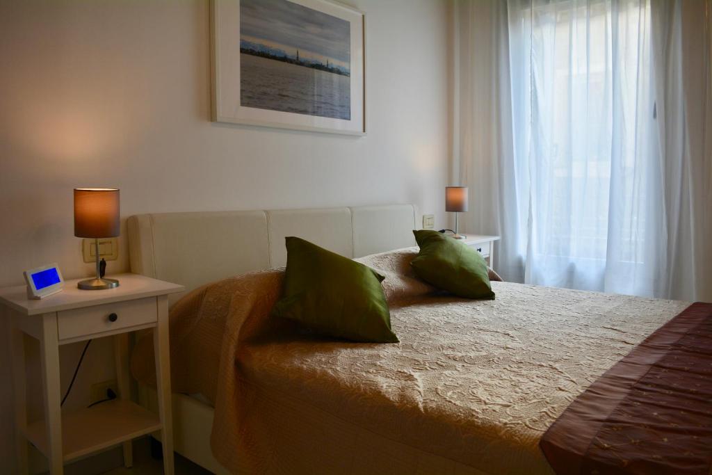 ein Schlafzimmer mit einem Bett mit grünen Kissen und einem Fenster in der Unterkunft Yellow House in Venedig