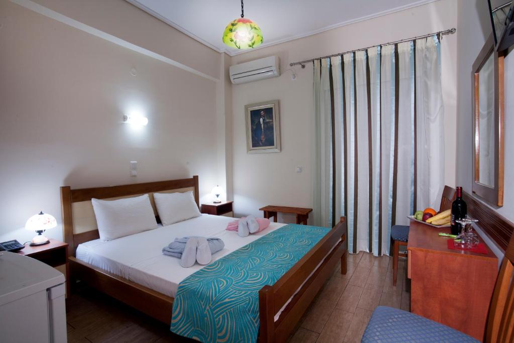 - une chambre avec un lit et des serviettes dans l'établissement Hotel Loutraki, à Loutraki