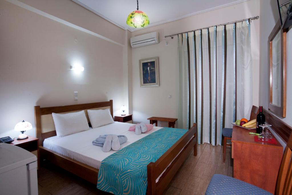 a bedroom with a bed with towels on it at Hotel Loutraki in Loutraki