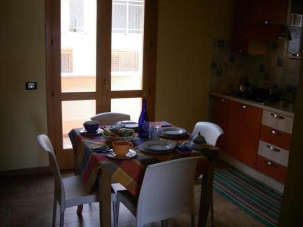 a dining room table and chairs with a table and a window at Casa Nel Corso in Castellammare del Golfo
