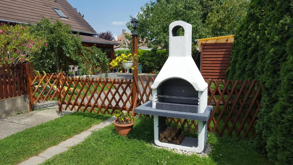a outdoor oven in a yard next to a fence at Erika vendégház centrumban in Balatonkeresztúr
