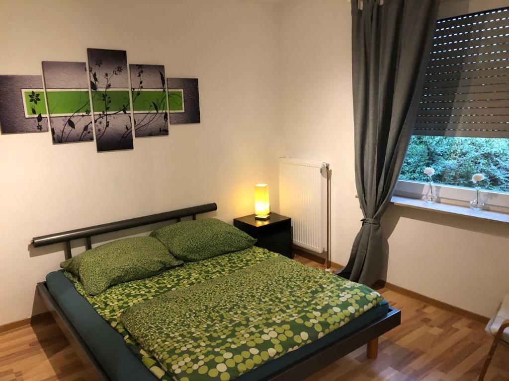 een slaapkamer met een groen bed en een raam bij Apartment Essen Holsterhausen in Essen