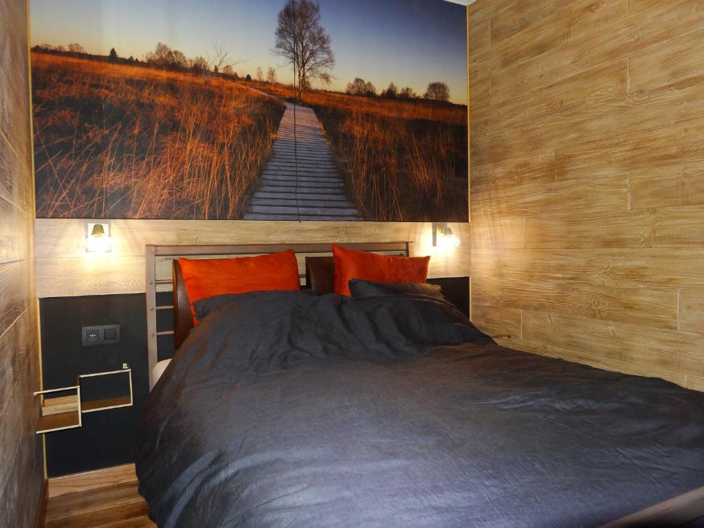 La mignonne des fagnes في مالميدي: غرفة نوم بسرير كبير عليها لوحة على الحائط