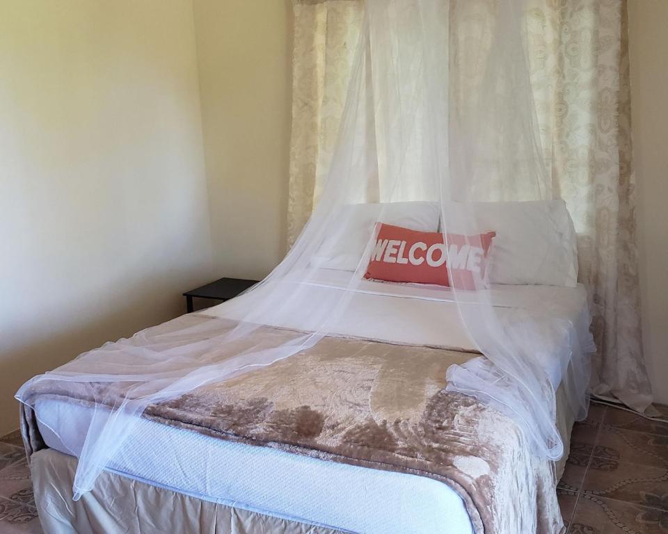 a bedroom with a bed with a net at Viva Violas in Port Antonio