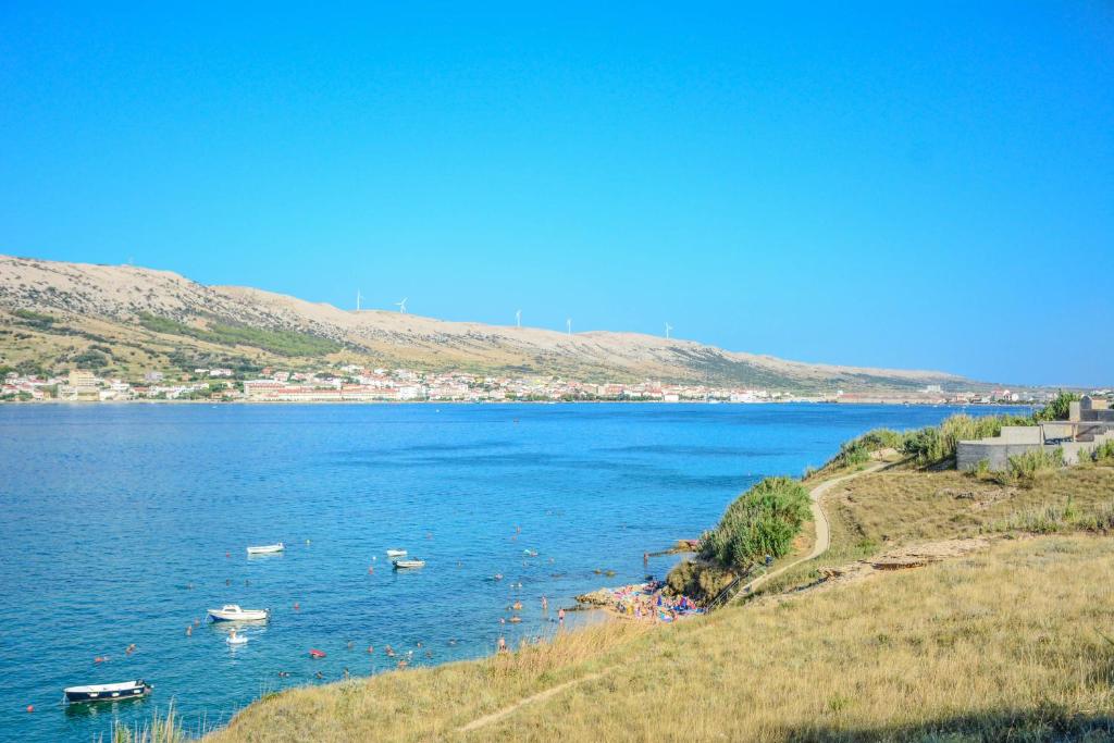 a large body of water with boats in it at Apartmani prvi red do mora in Pag