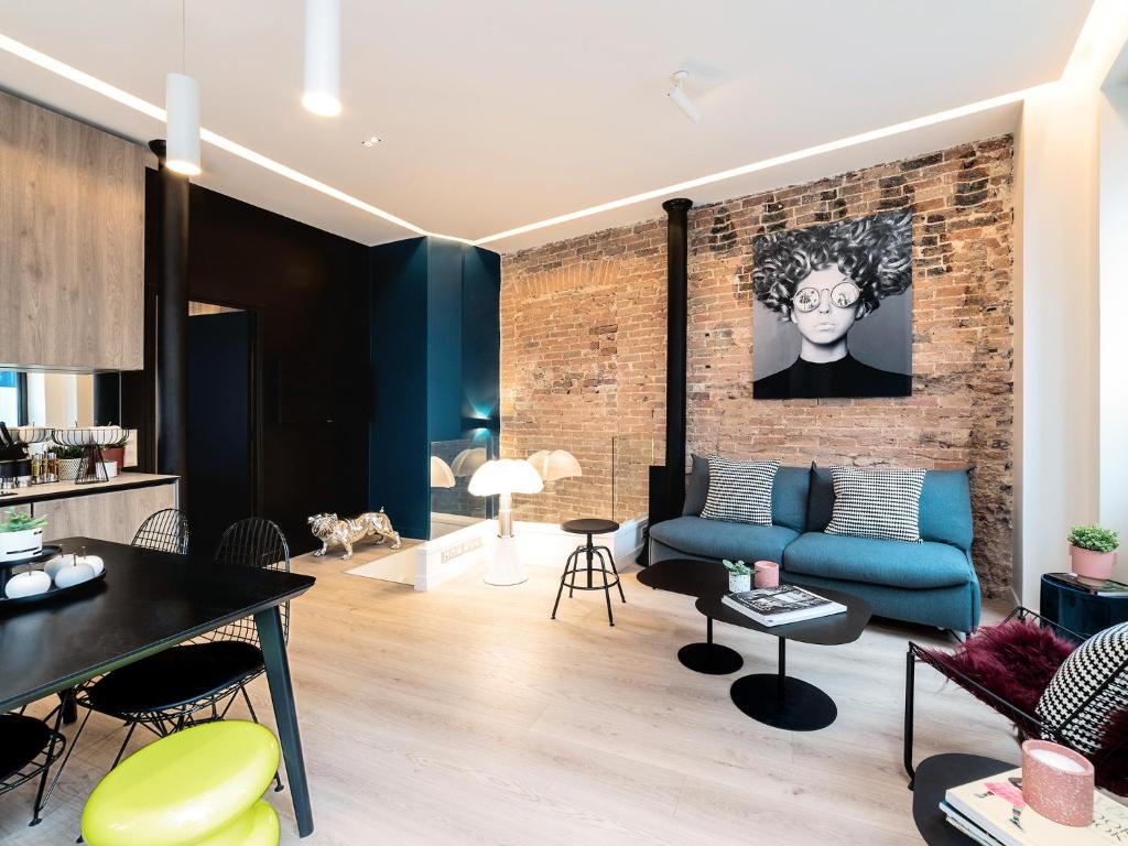パリにあるExclusive Loft in Le Marais with ACの青いソファとレンガの壁が備わるリビングルーム